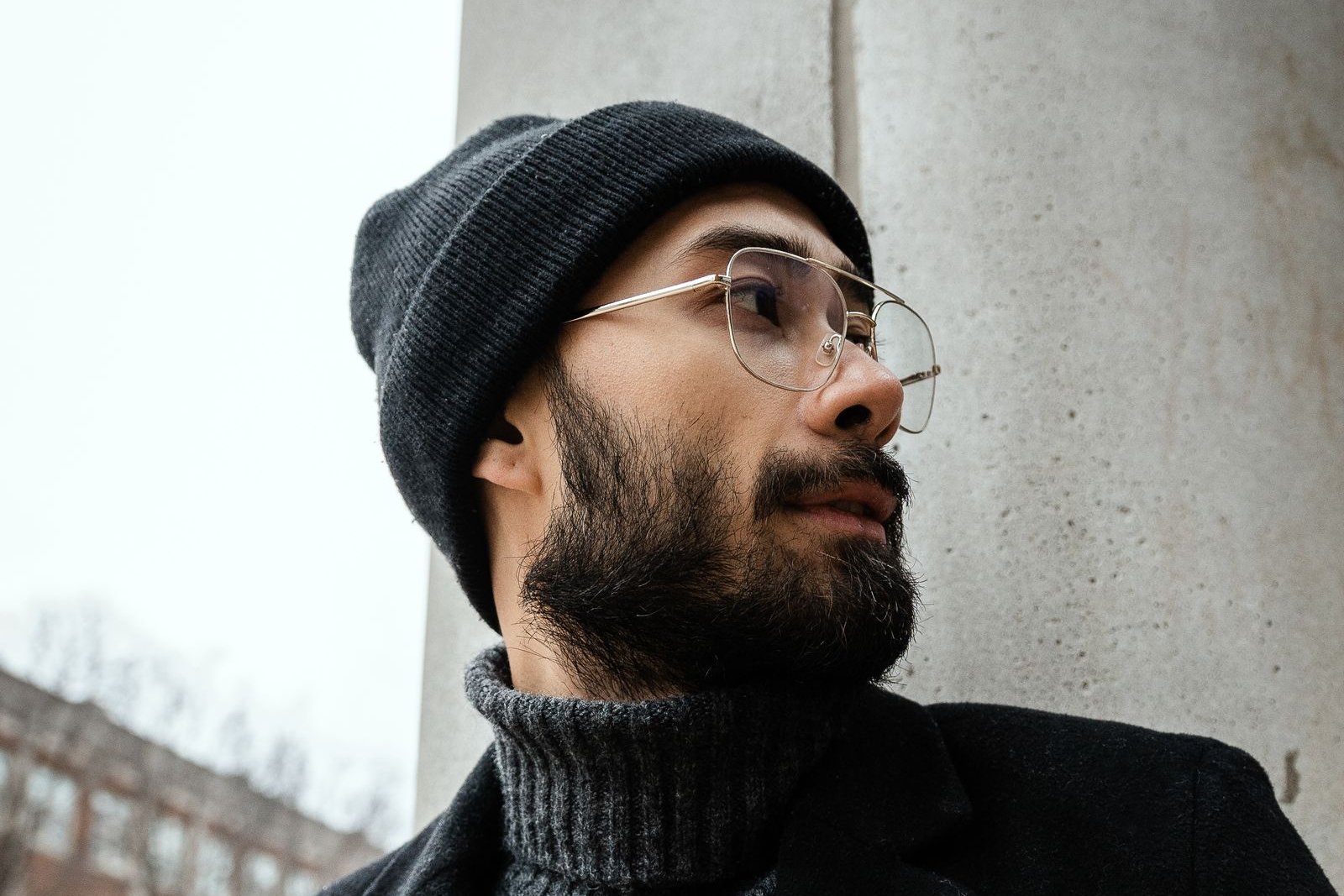 Bearded man in a black knitted cap and black coat, winter-ready cold weather beard style